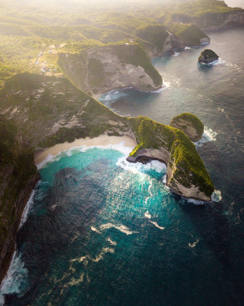 Stunning aerial view of Bali's coastline with turquoise waters and lush cliffs.